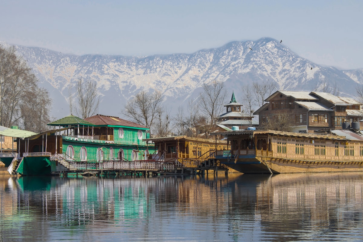 Houseboats on Dal Lake beneath snowy Kashmir peaks