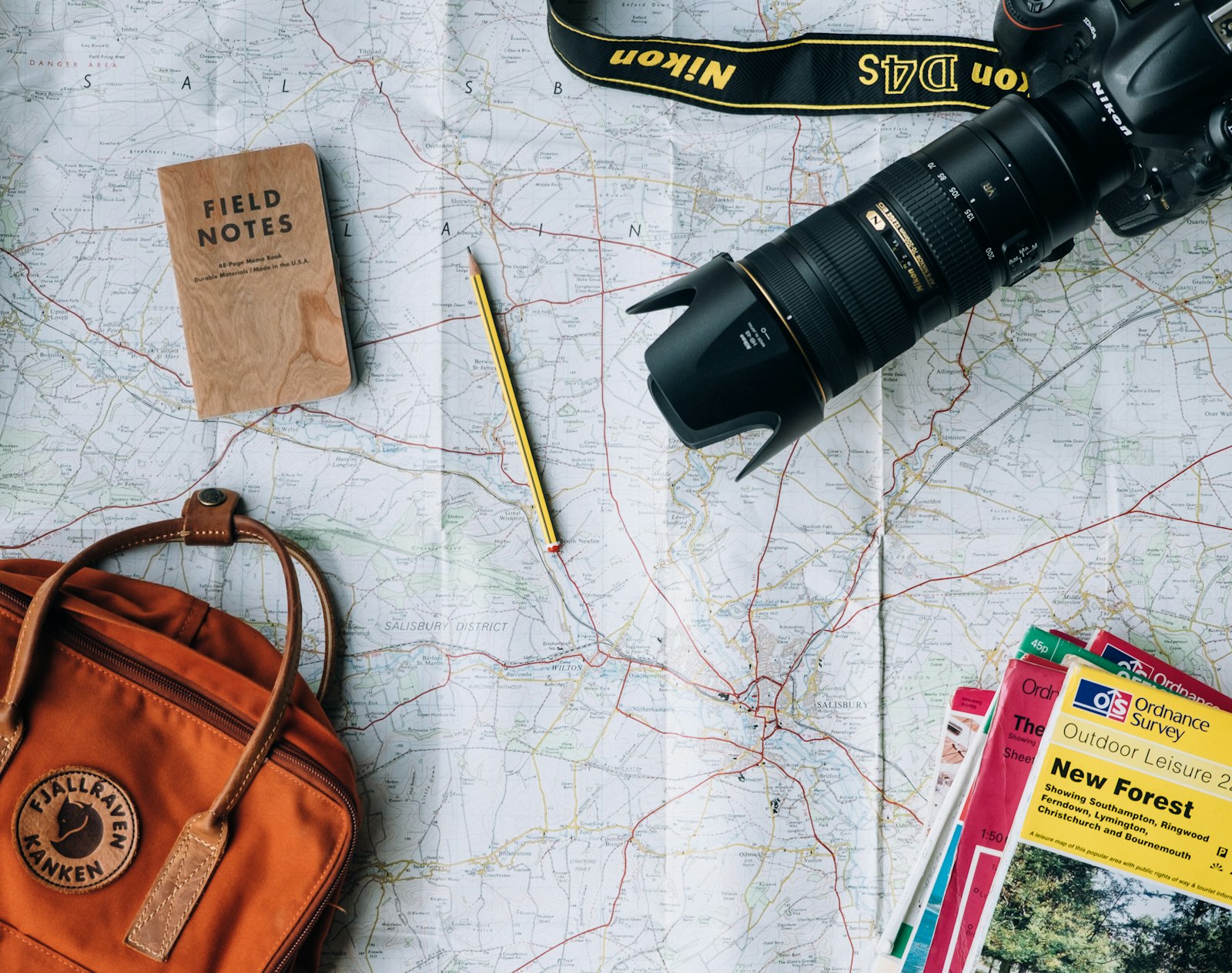 Trip planning flatlay with a map, camera and field notes