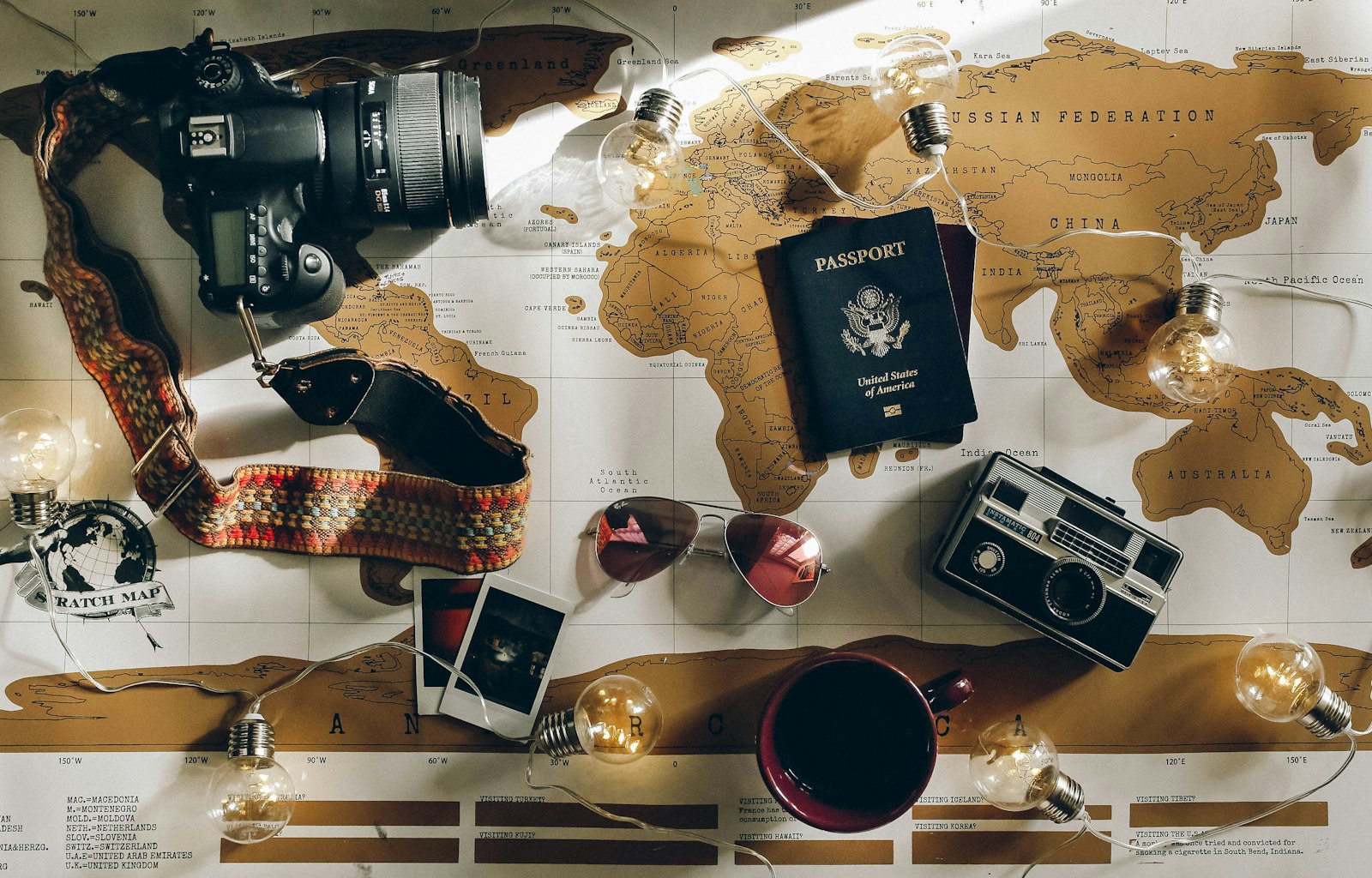 Passport laid on a world map with travel cameras